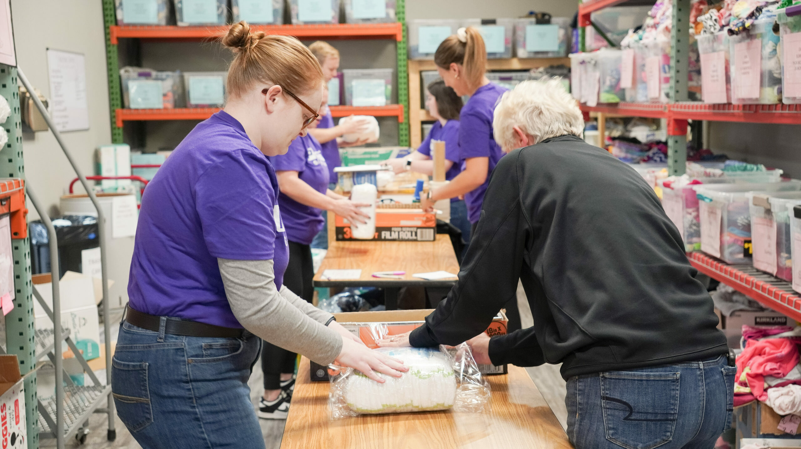 Pictures of Volunteer in Purple shirt wrapping diapers