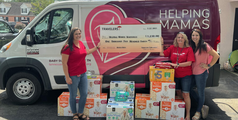 The Travlers Insurance Team posing in front of the van with their diaper donations and check 