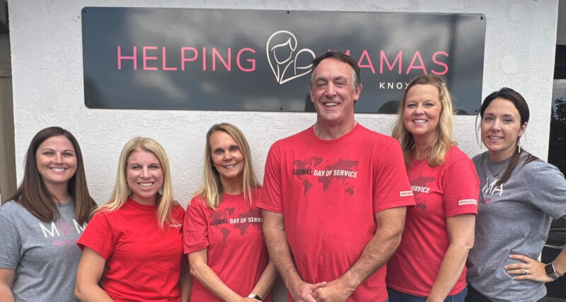 A Corporate Group Posing in front of the Helping Mamas Building